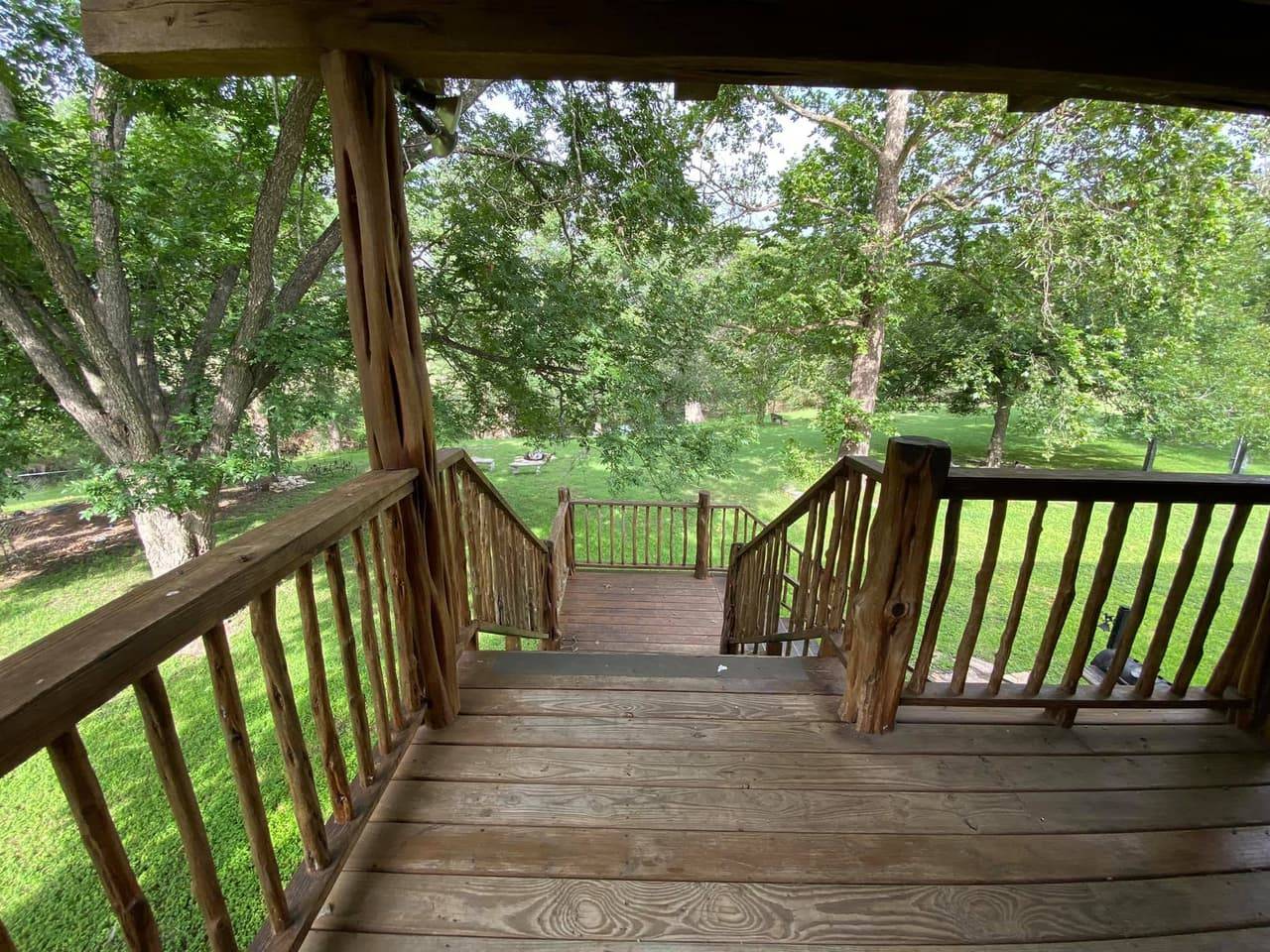 Lodge deck stairs descending to the lawn with an American flag flying in the distance