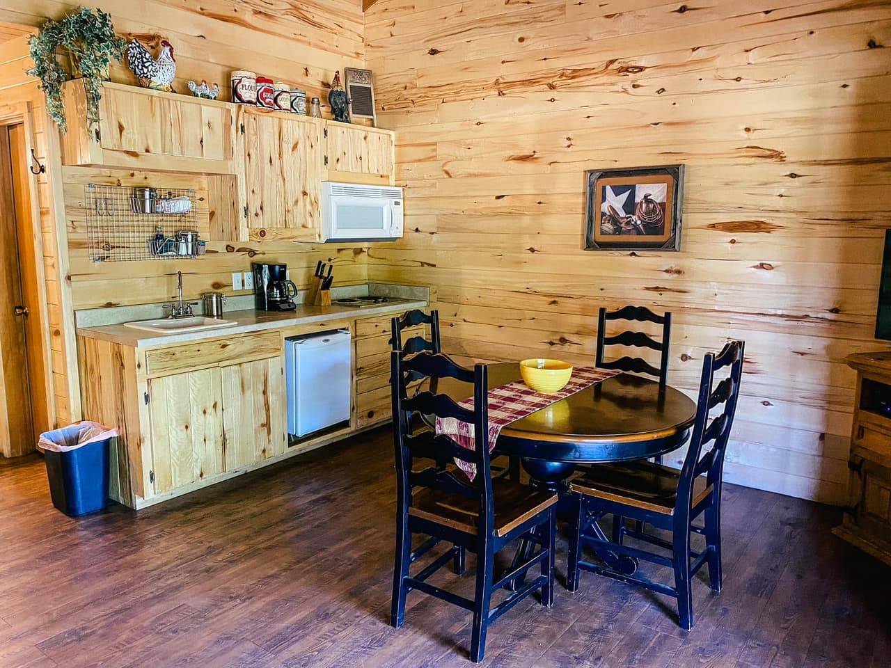 Lodge kitchenette and dining nook with a round table and chairs at Sabinal River Lodge