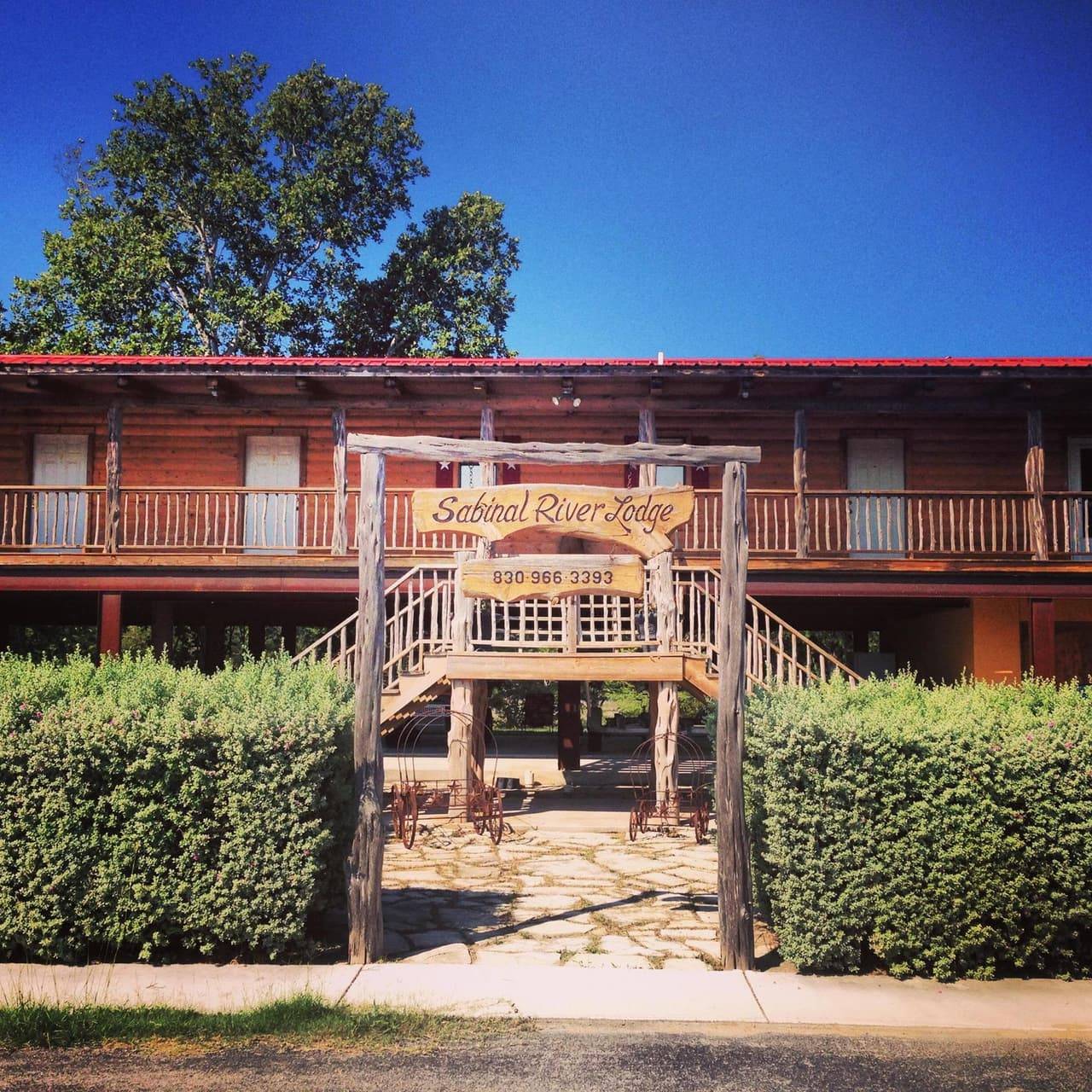 Sabinal River Lodge's long covered porch building lit by golden autumn light at dusk