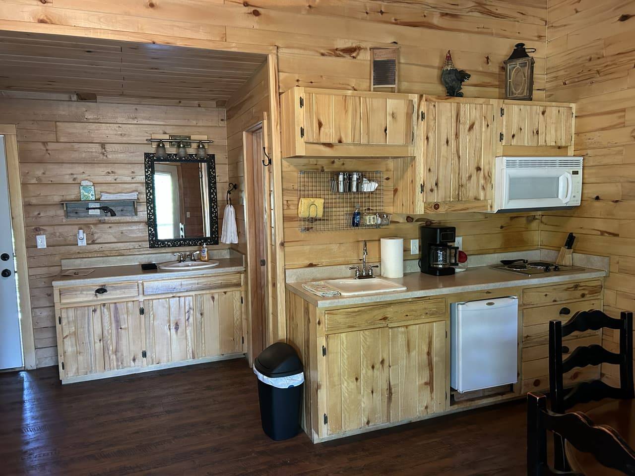 Log-style kitchenette with knotty pine cabinets, microwave, and coffee station