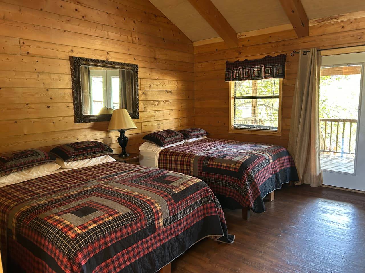 Riverview Double Queen at Sabinal River Lodge with two queen beds dressed in plaid quilts and a log bunk bed frame
